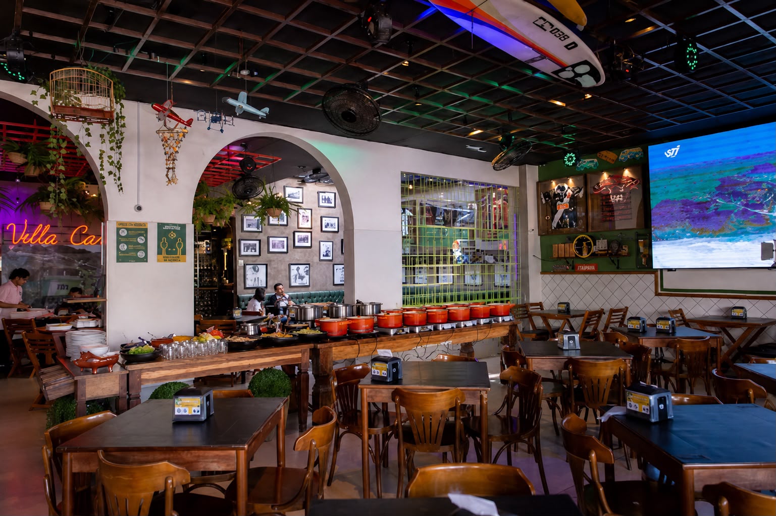 Buffet com panelas de ferro sob arcos e ambiente carioca